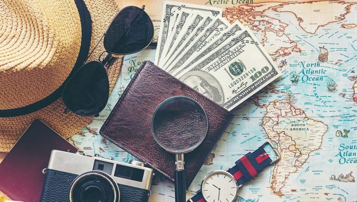 An image of a wallet full of money and a map for travel